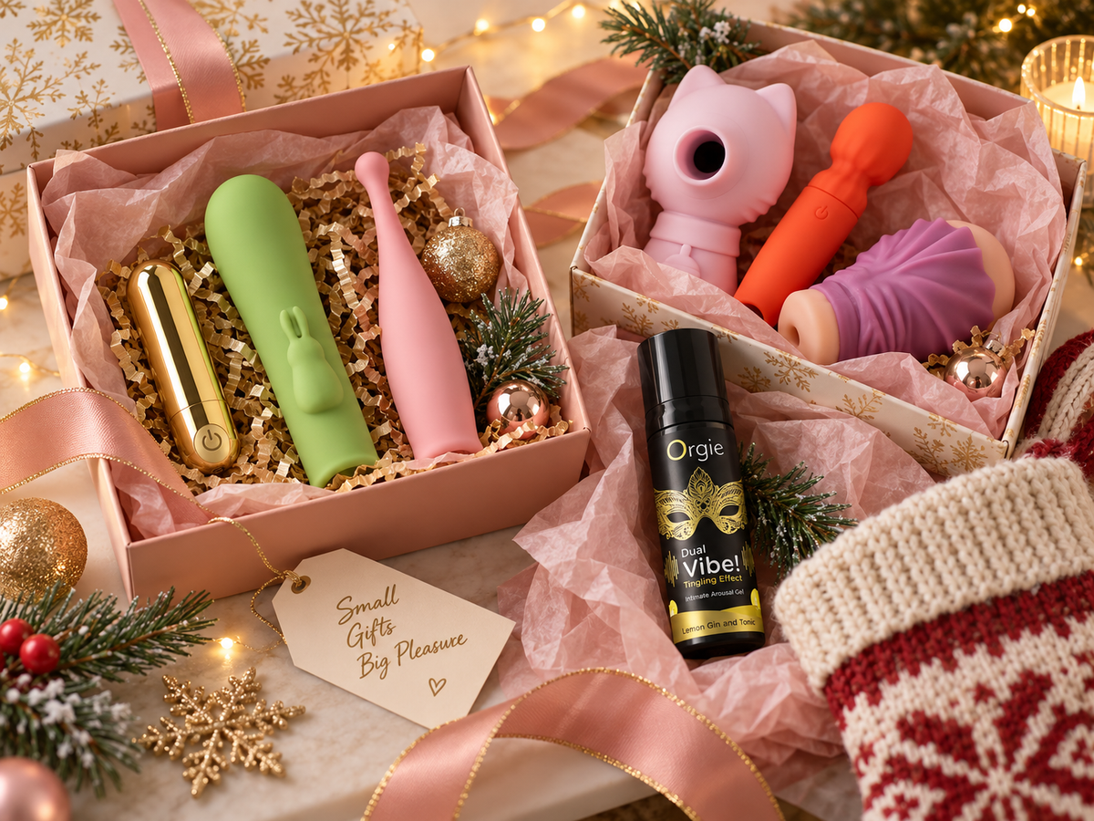 Holiday gift boxes styled as sex toy stocking stuffers with compact vibrators, a suction toy, a stroker, and arousal gel in festive pink packaging.