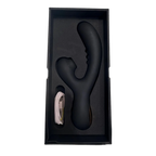 A matte black dual-stimulation personal massager shown inside its black presentation box with a foam insert, alongside a coiled white charging cable, on a plain white background.