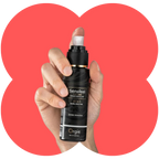 A hand holding a black pump bottle of Orgie Sensfeel Sensation Primer against a coral-red heart-shaped graphic on a white background.