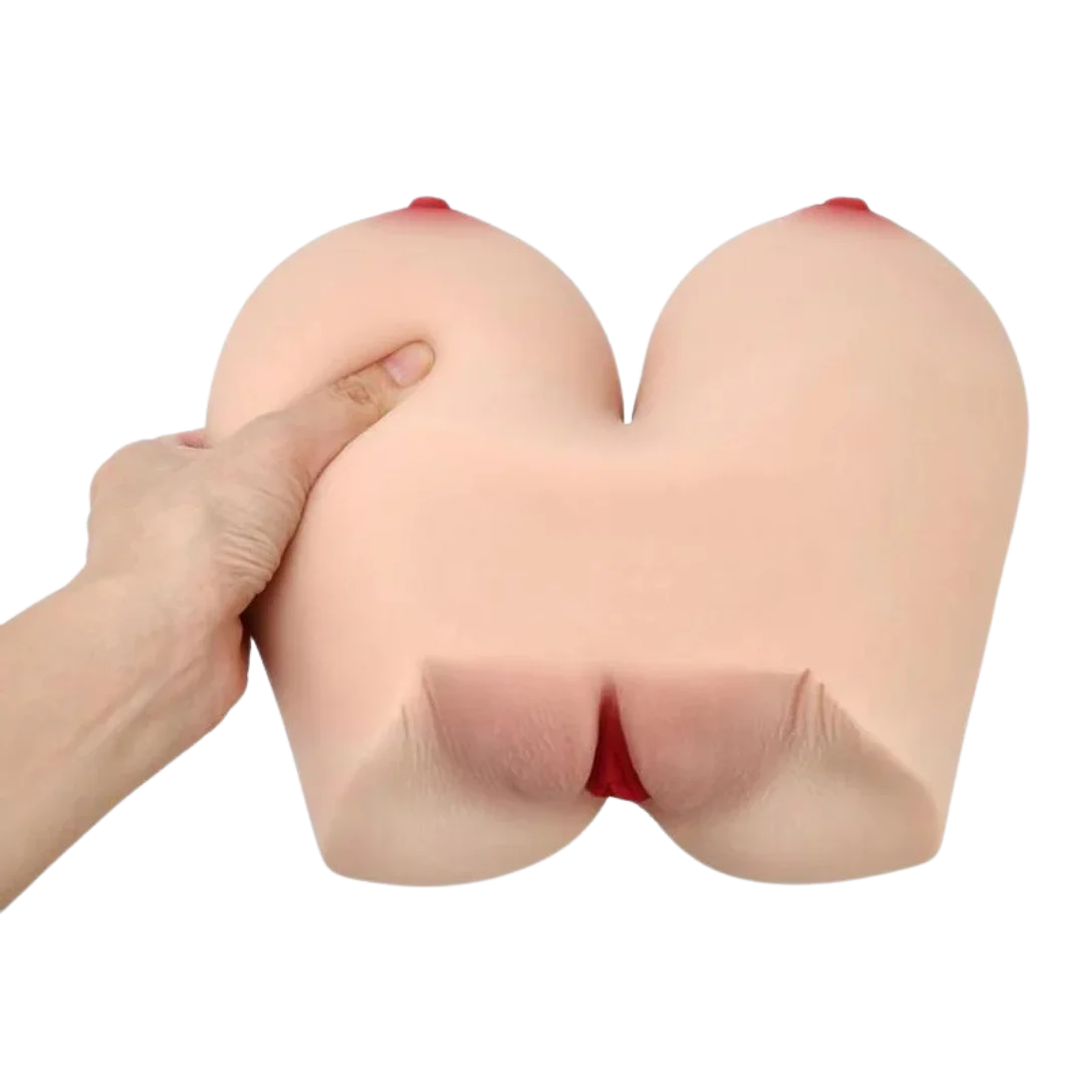 A silicone adult novelty titwoman  with realistic skin-toned texture, red nipple details, and a red opening at the center, shown with a hand pressing on one side against a white background.